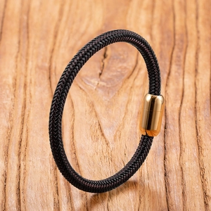 Nahaufnahme eines gewebten Armbands mit einem polierten goldenen Magnetverschluss