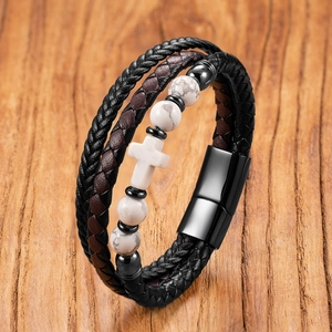 Detail eines mehrlagigen Lederarmbands mit weißem Marmorkreuz und Magnetverschluss
