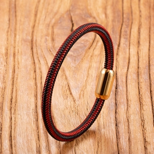 Nahaufnahme von handgewebtem Armband in Rot und Schwarz mit poliertem Gold-Magnetverschluss