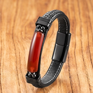 Detailed close-up of woven black leather men's bracelet with a red stone inlay and magnetic clasp