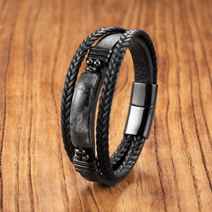 Détail d'un bracelet multicouche en cuir noir avec incrustation de pierre et fermoir magnétique