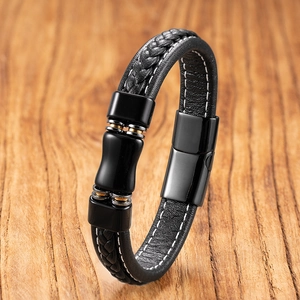 Detail of black braided leather men's bracelet with gold ring accent and steel clasp