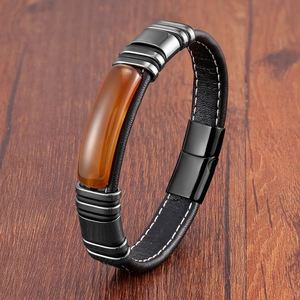 Detail view of men's leather bracelet with orange stone inlay and magnetic clasp