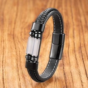 Detail of woven black leather bracelet with white stitching and magnetic metal clasp