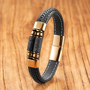 Detail of black braided leather bracelet with golden magnetic clasp and lava stone beads