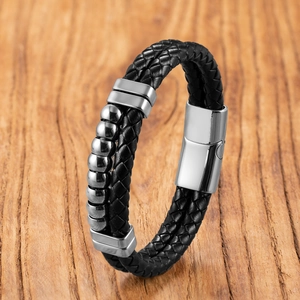 Dettaglio di bracciale da uomo in pelle nera intrecciata a doppio strato con perle d'acciaio