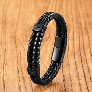 Dettaglio di bracciale in pelle intrecciata nera da uomo con perle e chiusura magnetica