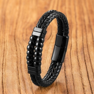 Dettaglio del bracciale a doppio strato in pelle nera intrecciata con chiusura opaca
