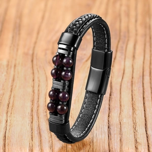 Detail eines mehrlagigen schwarzen Lederarmbands mit Tigerauge-Perlen und Metallverschluss
