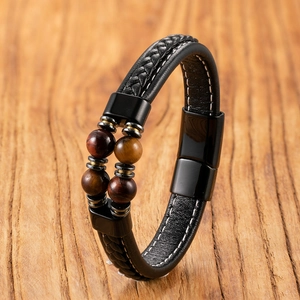 Detail of tiger eye beads and braided leather cord on a men's bracelet with black magnetic clasp