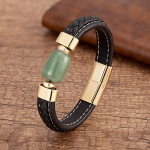 Dettaglio del bracciale in pelle intrecciata da uomo con pietra verde e chiusura dorata