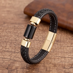 Dettaglio del bracciale in pelle nera intrecciata con chiusura in metallo oro