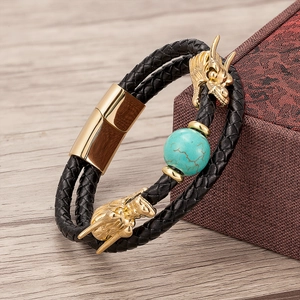 Detail of double-layer black leather bracelet with golden dragon heads and turquoise bead