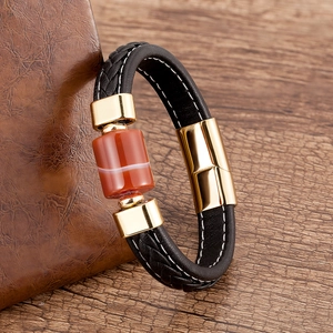 Dettaglio del bracciale in pelle nera intrecciata con agata rossa e chiusura dorata