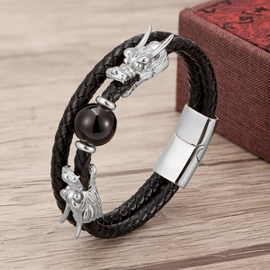 Close-up of double-layer woven leather bracelet with silver dragon heads and black bead