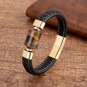 Dettaglio del bracciale in pelle intrecciata con occhio di tigre e chiusura d'oro