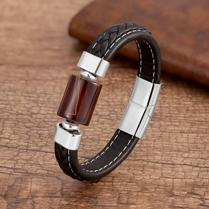 Dettaglio del bracciale in pelle intrecciata con pietra d'agata marrone e chiusura in argento