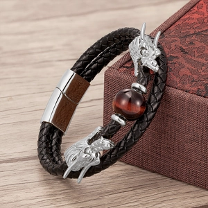 Detailed macro of double-layered leather bracelet with dragon charms and tiger eye stone