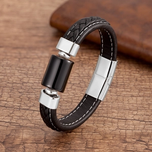 Macro dettagliata di un bracciale in pelle intrecciata da uomo con chiusura magnetica argento