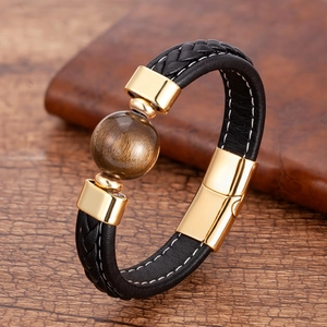 Detail eines schwarzen Lederarmbands mit Tigerauge-Stein und goldenem Magnetverschluss