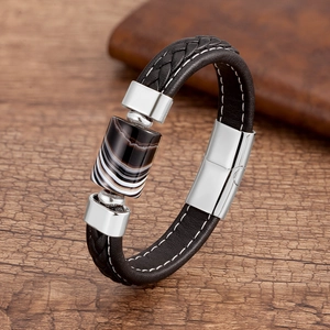 Dettaglio macro del bracciale in pelle nera intrecciata con perla d'agata e chiusura magnetica