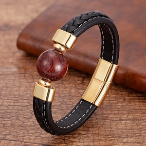 Nahaufnahme von geflochtenem Lederarmband mit Mahagoniperle und goldenem Magnetverschluss