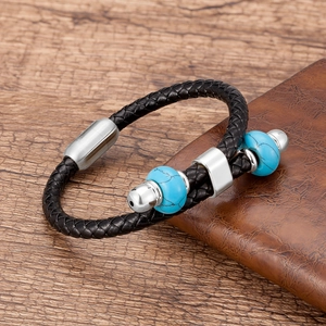 Macro-opname van zwart gevlochten leren armband met blauwe kralen en stalen sluiting