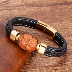 Detail von Buddha-Kopf und geflochtenem schwarzem Leder mit goldenem Magnetverschluss