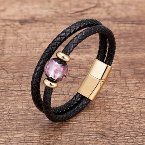 Dettaglio del bracciale doppio in pelle intrecciata con chiusura magnetica e perla viola