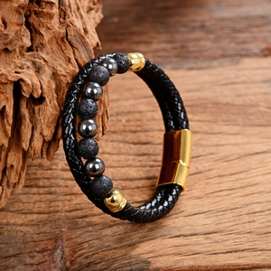 Detail of men's double-layer leather rope bracelet with lava stones and gold magnetic clasp