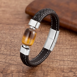 Dettaglio di un bracciale da uomo in pelle intrecciata con pietra naturale occhio di tigre