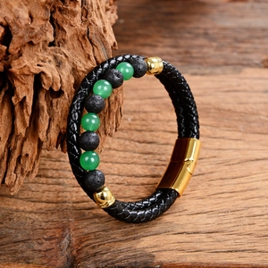 Macro shot of double-layer black leather bracelet with green stone and magnetic gold clasp