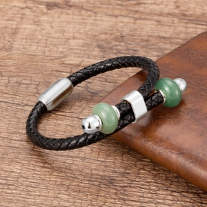 Macro-opname van gevlochten leren armband met groene kralen en zilveren magnetische sluiting