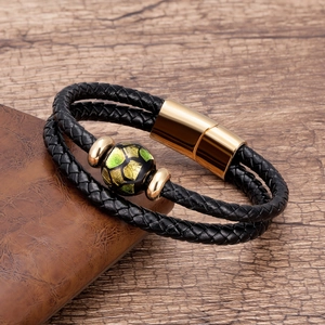 Dettaglio ravvicinato del bracciale in pelle intrecciata a doppio strato con chiusura oro