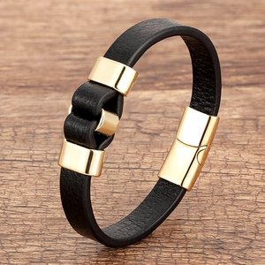 Classic braided black leather bracelet with polished gold magnetic clasp on wood surface