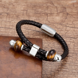Detail van een gevlochten leren armband met stalen magneetsluiting en tijgeroogstenen