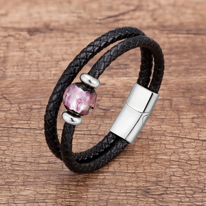 Dettaglio del bracciale in pelle intrecciata a doppio strato con perla in marmo viola