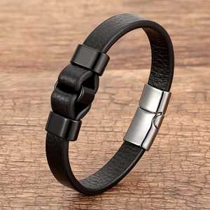 Men's minimalist black leather bracelet with silver magnetic clasp on wood surface