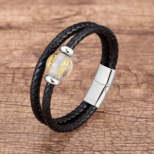 Geflochtenes Herren-Lederarmband mit silbernen Perlen und Magnetverschluss auf Holzgrund