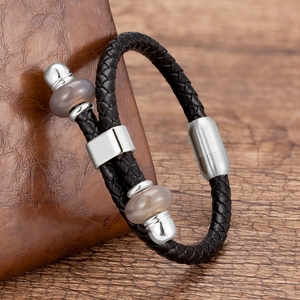 Detail van een handgeweven zwart leren armband met magneetsluiting en kwartskralen