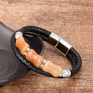 Détail d'un bracelet en cuir tressé multicouche avec perles orange et fermoir magnétique