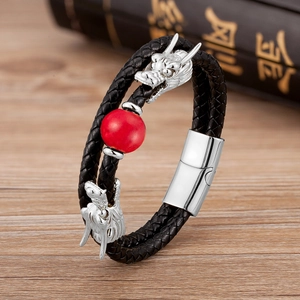 Detalle de pulsera de cuero trenzado de doble capa con cabezas de dragón y una cuenta roja