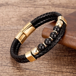 Détail du bracelet en cuir tressé noir avec fermoir doré et perles de pierre noire