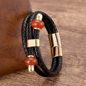 Dettaglio del bracciale in pelle intrecciata con perle di agata e chiusura dorata