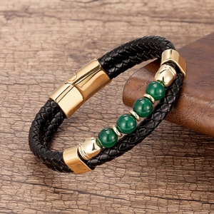 Détail de bracelet en cuir tressé noir avec perles vertes et fermoir magnétique doré