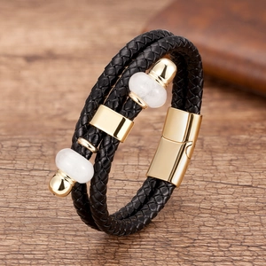Dettaglio del bracciale in pelle intrecciata multistrato con chiusura magnetica dorata