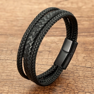 Detailed macro view of triple-strand black braided leather bracelet with magnetic clasp