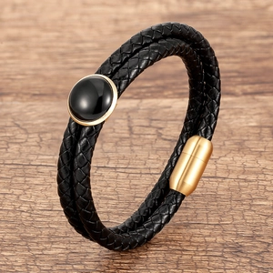 Dettaglio del bracciale in pelle nera a doppio strato con chiusura magnetica d'oro
