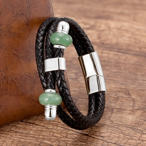 Dettaglio di un bracciale in pelle intrecciata con chiusura magnetica e perle