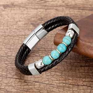 Détail du bracelet en cuir tressé noir avec cinq perles turquoise et fermoir en acier